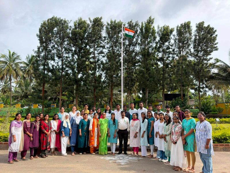 The photograph captures the Independence Day celebration at Mysuru Royal Institute of Technology (MRIT), Mandya, with the Honourable Treasurer, Dr. Ra