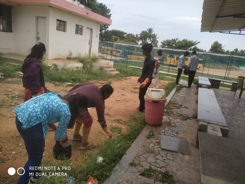 The photograph shows an NSS Cleanliness Drive conducted by student volunteers on the college campus.